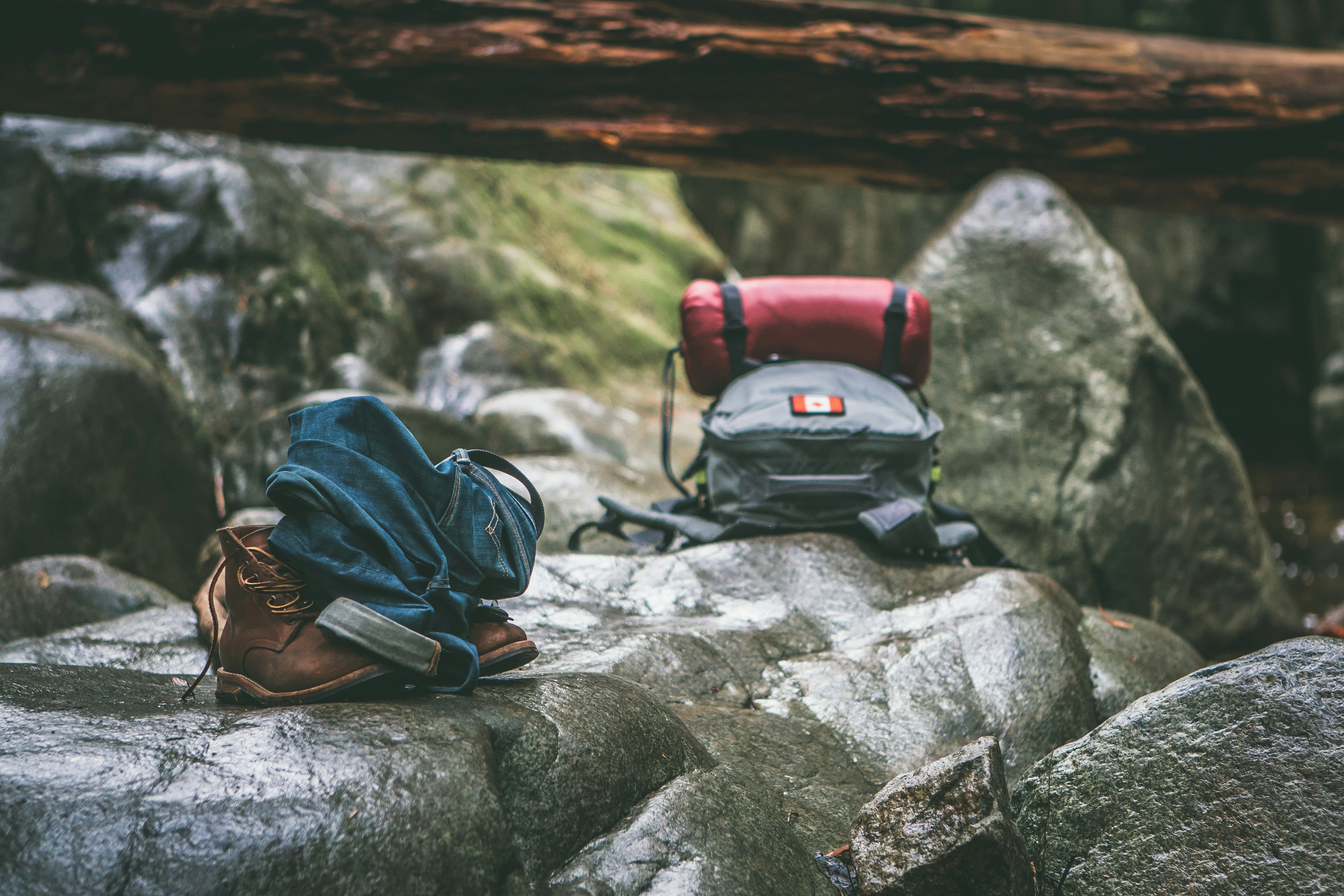 Hiking boots and backpack at a forest campsite