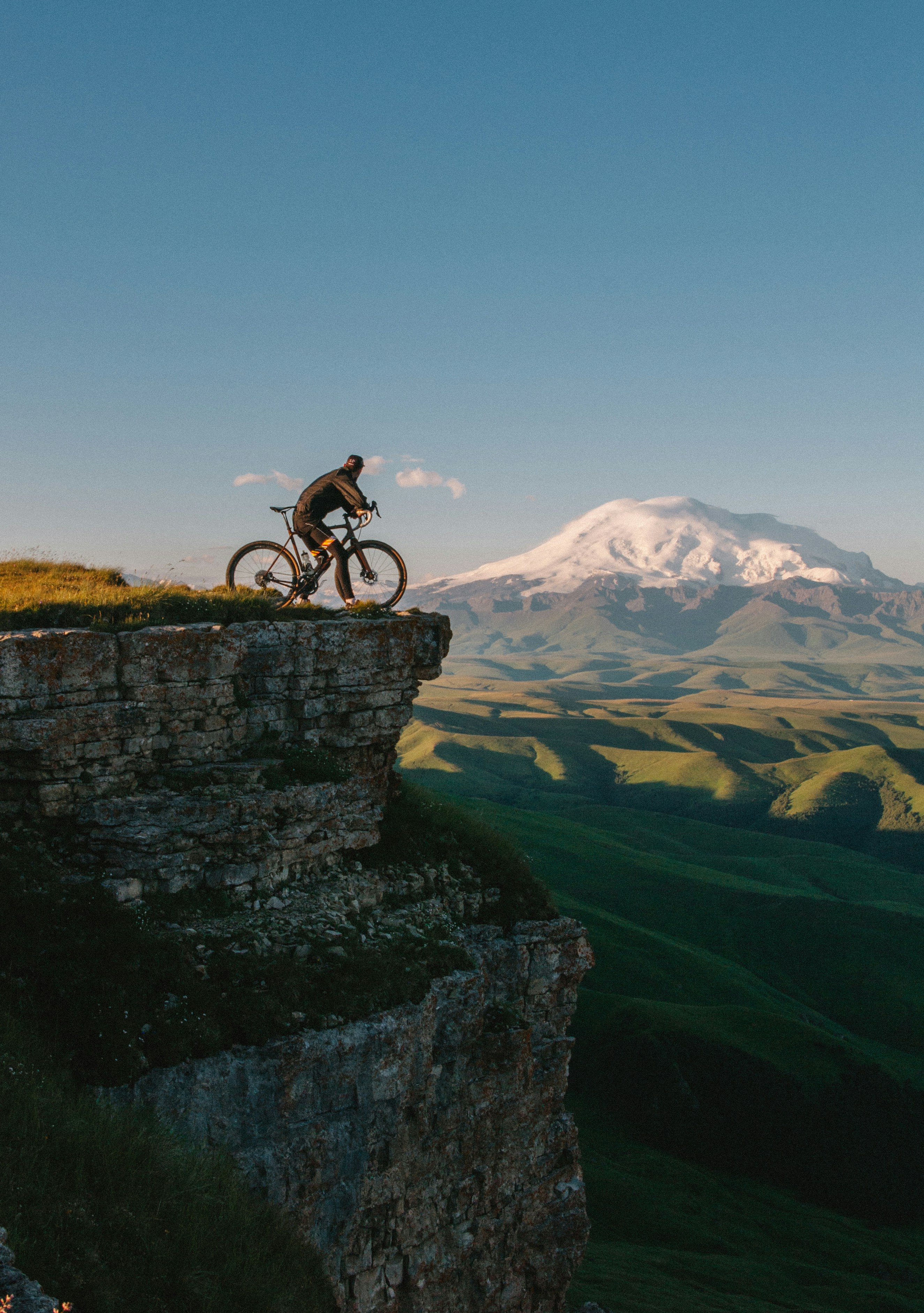 Mountain biker riding along a clifftop ridge