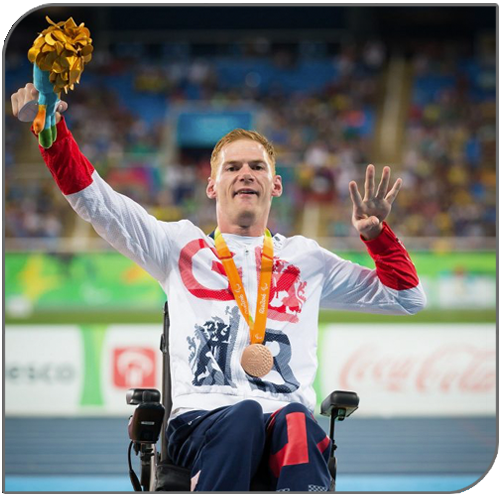 Stephen Miller MBE on the podium with a Paralympic medal and a bouquet, wearing a Great Britain top