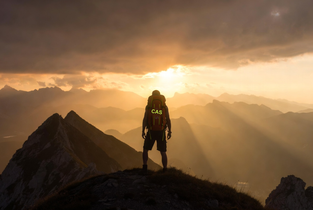 A lone explorer on a mountain summit at sunset carrying a CAS-Straps backpack