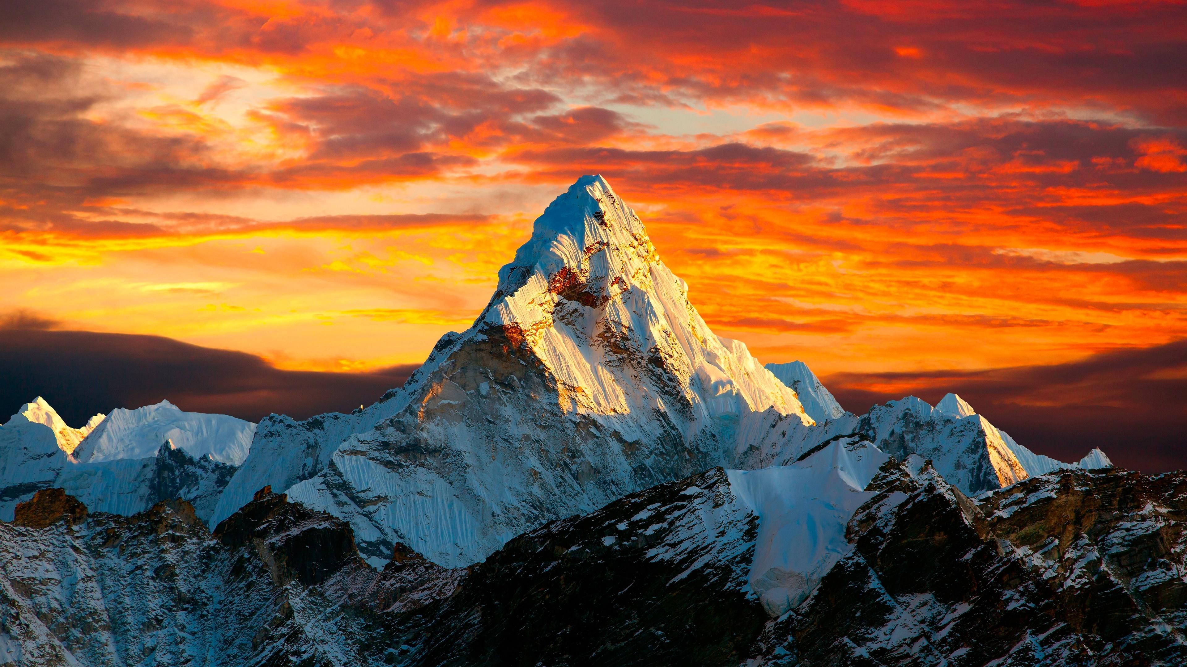 Snow-capped mountain peak glowing at sunset